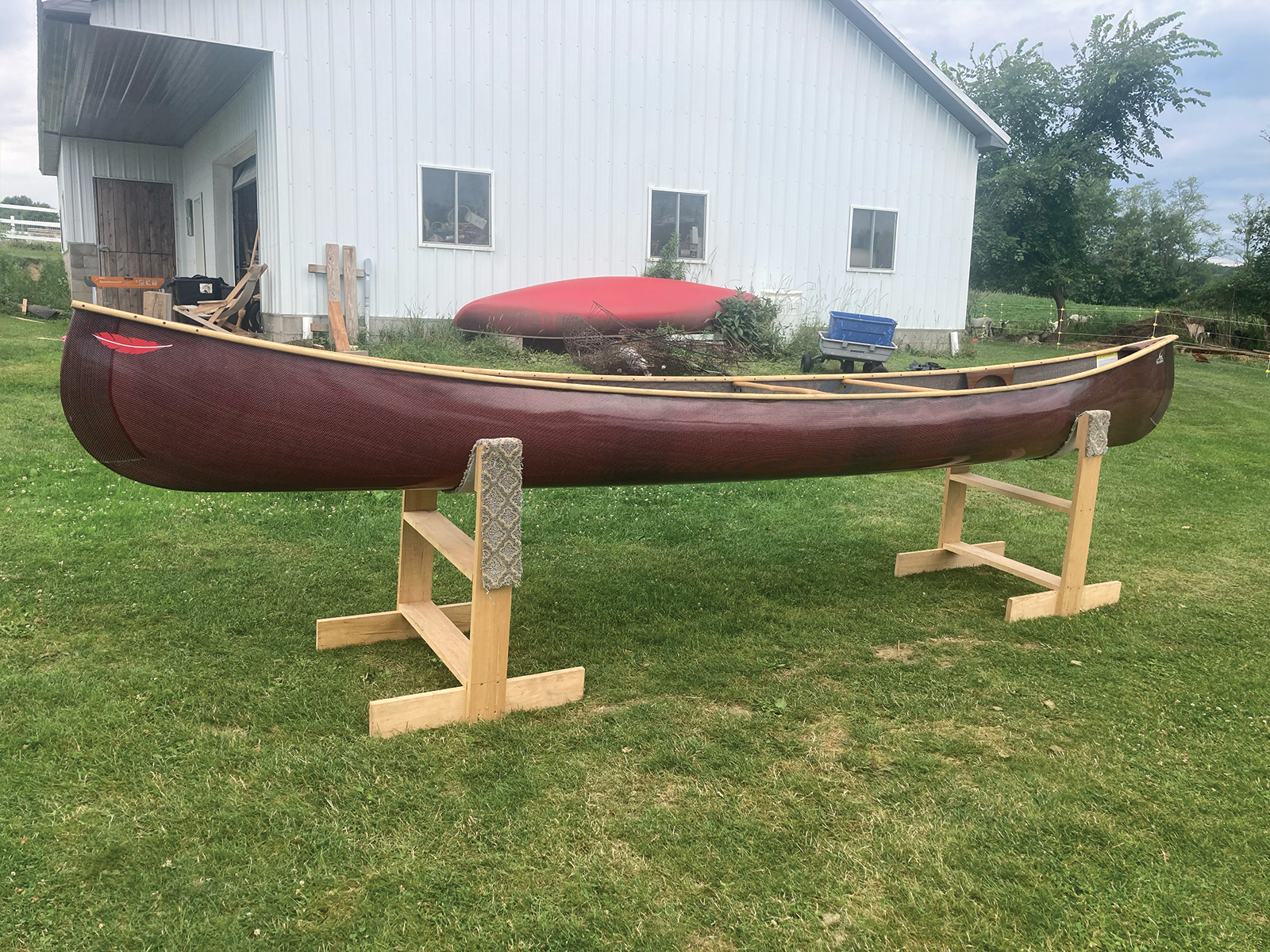 Port view of Redfeather Prospector with red hull and ash gunwales