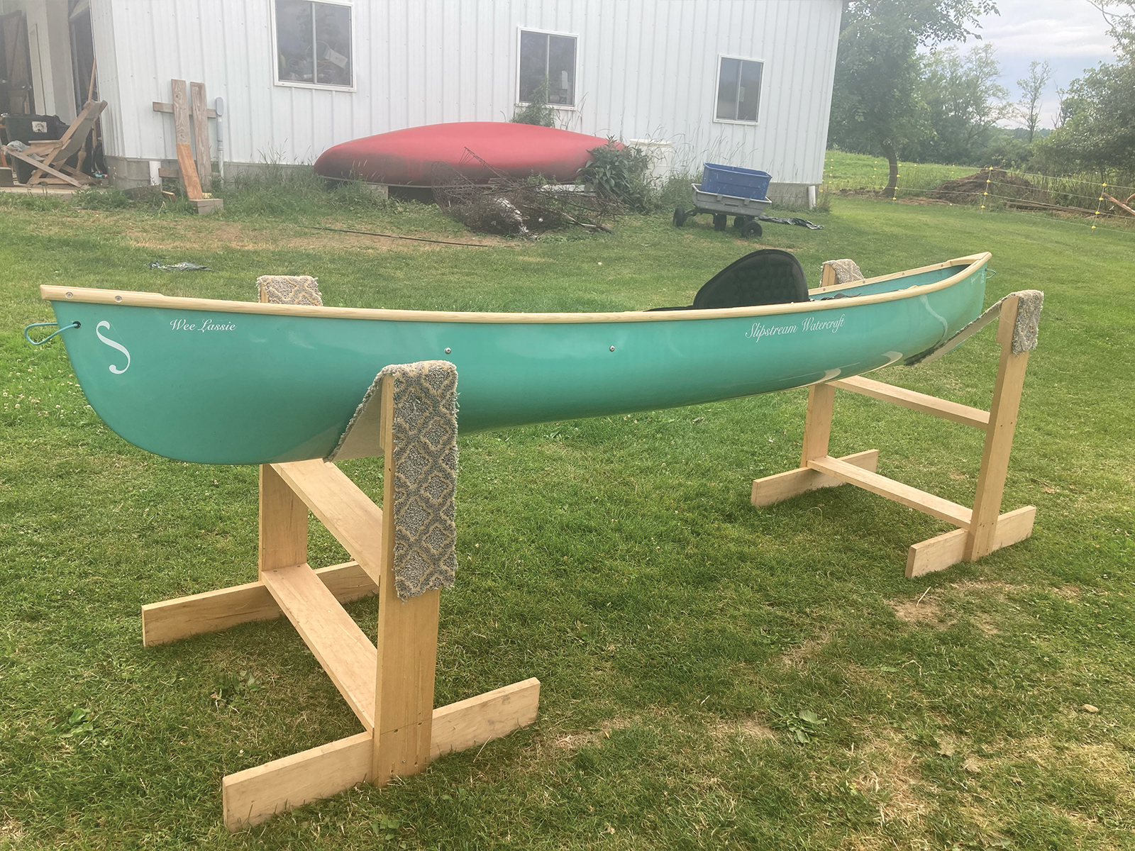 Port view of the Slipstream Wee Lassie Canoe with hand laminated teal hull and ash Gunwales