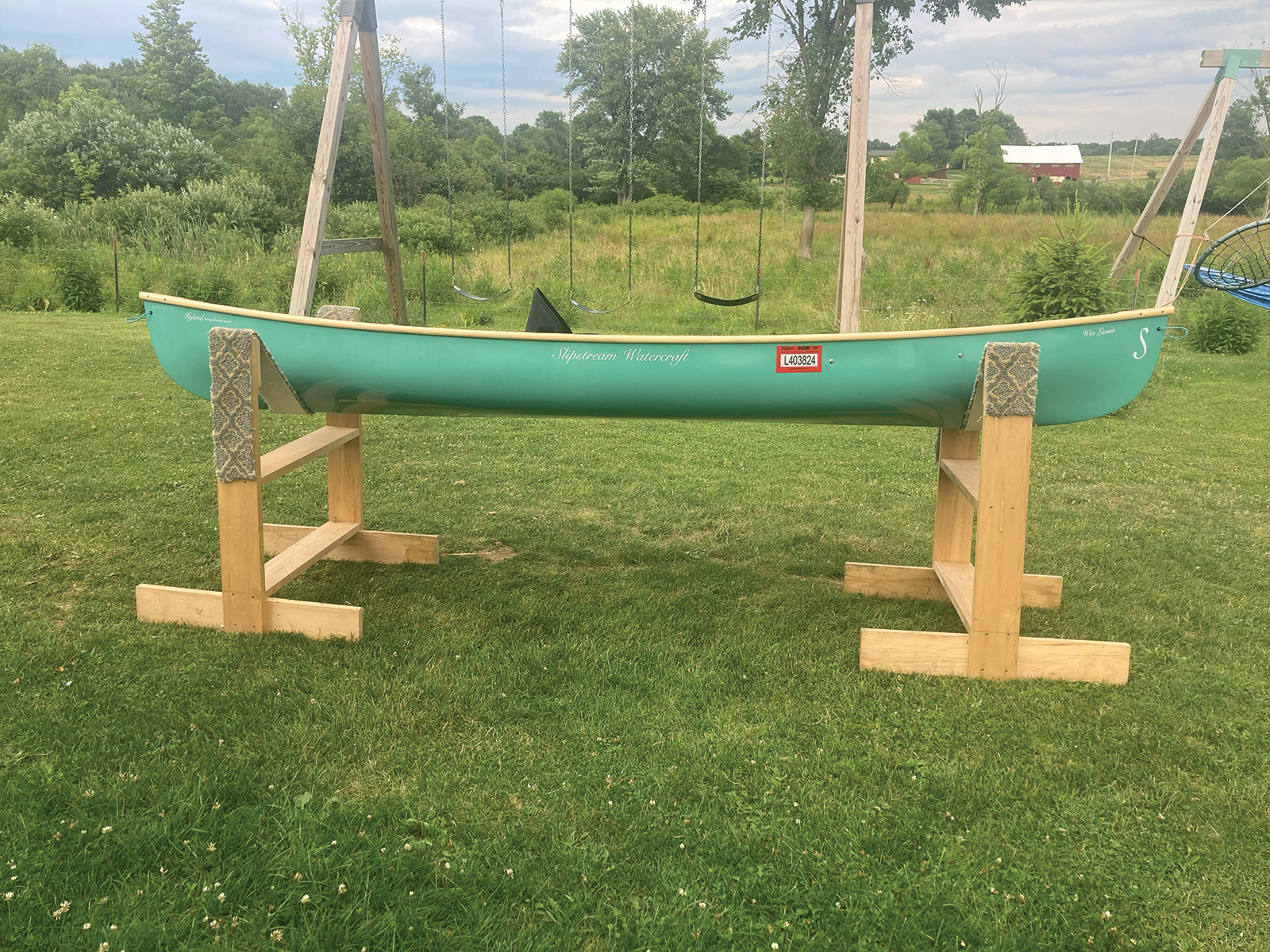 Starboard view of the Slipstream Wee Lassie Canoe with hand laminated teal hull and ash Gunwales