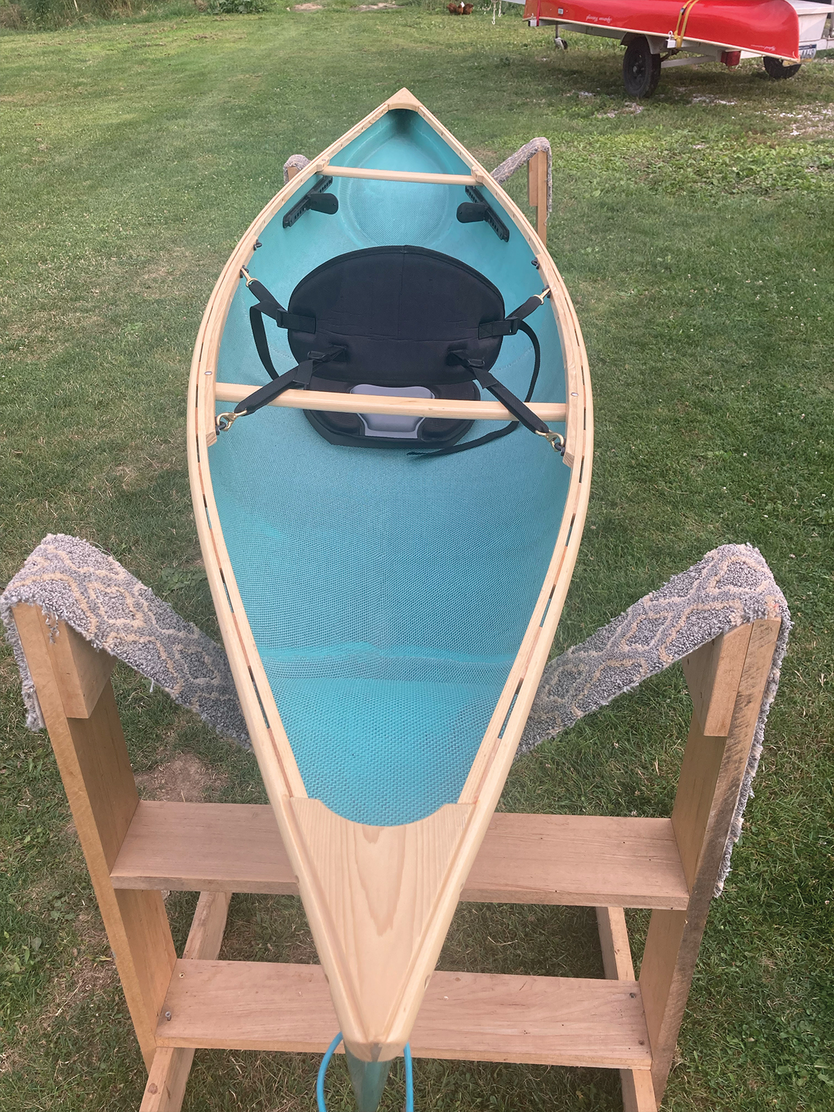 Overhead, stern to bow view of the Slipstream Wee Lassie Canoe with hand laminated teal hull and ash Gunwales