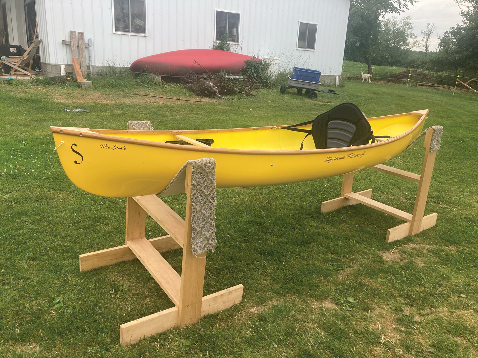 Port view of the Slipstream Wee Lassie Canoe with hand laminated egg yolk (yellow) hull and cherry Gunwales