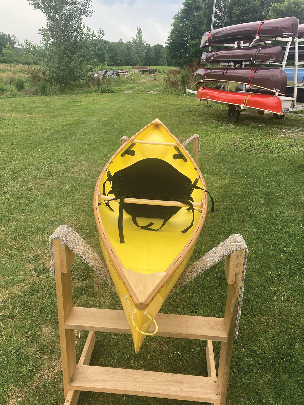 Overhead, stern to bow view of the Slipstream Wee Lassie Canoe with hand laminated egg yolk (yellow) hull and cherry Gunwales